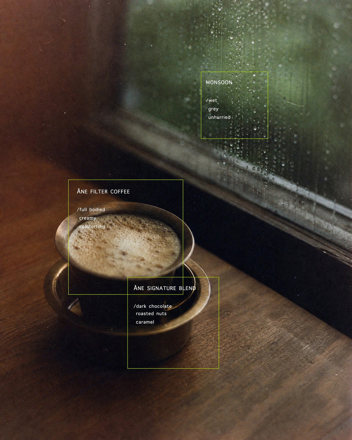 A cup of Āne filter coffee with milk by a rain-streaked window